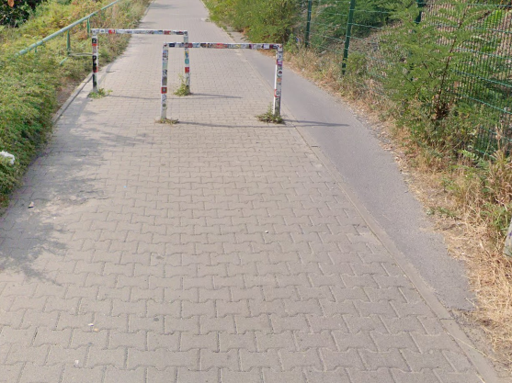 photograph of a now-paved path around a barrier